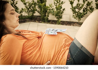 Dollars Lie On The Belly Of A Pregnant Woman (the Concept Of Surrogate Motherhood)