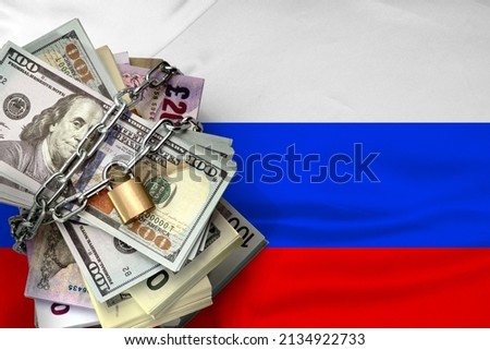 Dollars, lock, chain on the background of the Russian flag. Monetary crisis, financial problems, sanctions, default. The concept is up-to-date relevant situation in economics and politics.
