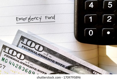 Dollars Money And Calculator , Notebook With Text Written EMERGENCY FUND , Concept Of Financial Plan - Saving Money For Crisis Tough Time