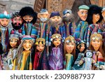 Dolls dressed in traditional uzbek costumes. Traditional souvenir puppet from painted mashed paper (papier mache). Itchan Kala (Xiva Ichon Qala). Khiva, Uzbekistan. Souvenir and gift concept
