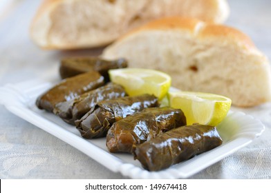Dolmades with lemon wedges and pita bread
