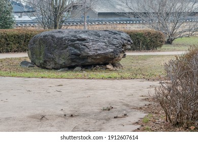 Dolmen burial chamber with large boulder used as capstone on top of smaller stones in neolithic park.