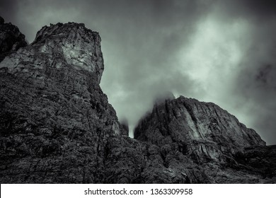 Dolomite mountain range, dramatic scenery in black and white with clouds and fog
