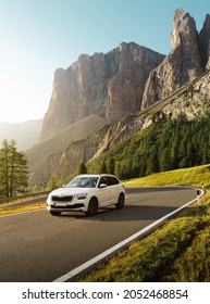 Dolomites, Italy - 05-10-2021: Brand new SKODA kamiq 2021 is driven at empty countryside asphalt road at sunset with beautiful view of mountain. Car in the ride. Roadtrip. 

