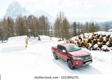 Dolomites, Italy -  December, 2018: The Red New Toyota Hilux 2018 Double Cab 4x4 Pickup Truck Running On The Mountain Road In Dolomite, Italy, Winter, Snow 