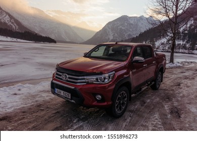 Dolomites, Italy -  December, 2018: The Red New Toyota Hilux 2018 Double Cab 4x4 Pickup Truck Running On The Mountain Road In Dolomite, Italy, Winter, Snow 