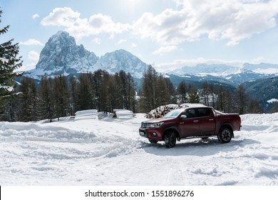 Dolomites, Italy -  December, 2018: The Red New Toyota Hilux 2018 Double Cab 4x4 Pickup Truck Running On The Mountain Road In Dolomite, Italy, Winter, Snow 