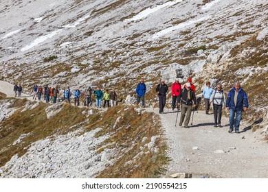 Dolomites, Italy, October, 2018, Group With Senior Citizen Walking On A Mountain Path