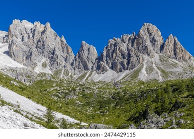 Dolomiti Alps beautiful mountain landscape. Rocky tower alpine summits in the Dolomites. Summer mountain scenic view on the hiking trekking path in the green mountain valley and blue sky with clouds - Powered by Shutterstock