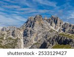 Dolomiti Alps mountain peaks in summer landscape on sunny weather beautiful day. Alpine scenery of the high rocky cliffs towering above green valleys in the Dolomites. Alpi Dolomiti summits blue sky