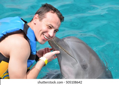 dolphin kiss man in blue clean caribbean water