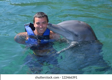 Dolphin swim and kiss man