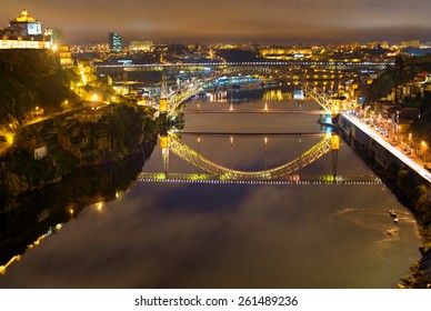 Dom Luis bridge reflected in Duoro river at night. Porto, Portugal
