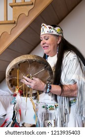 Domaine Cataraqui, Quebec City, Quebec, Canada, October 27, 2018 - Native Woman From Wendake In Ceremonial Dress Singing And Playing Traditional Drum During First Nations Workshop