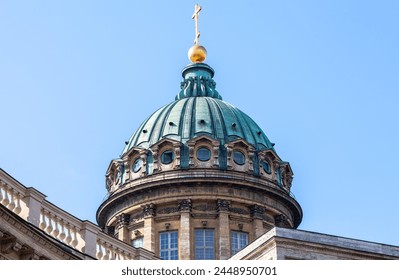 Dome of the Kazan Cathedral with golden religious cross against a blue sky in St. Petersburg, Russia