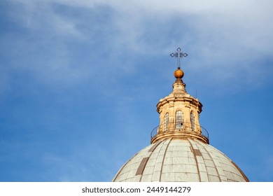 Dome of Palermo Cathedral, Sicily, Italy. A serene sky forms the backdrop for the ethereal dome of the Palermo Cathedral, topped with a cross and an orb, symbols of faith and tradition