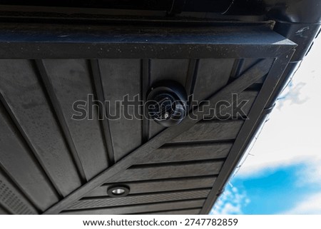 Dome security camera installing under a building roof providing property surveillance