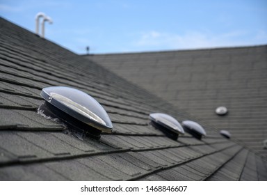 Dome shaped solar tube skylight on asphalt shingle roof  - Powered by Shutterstock