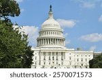 The dome of the United States Capitol building.  Western front.  A hot, sunny day in Washington, D.C.  Trees in the foreground.  Walking from Union Station towards the National Mall.  August 2019.