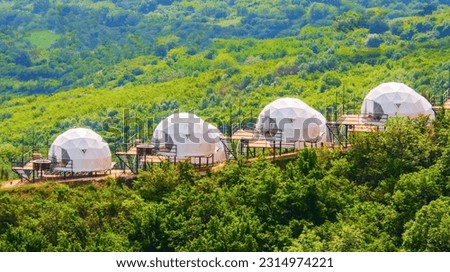 Domed houses in Georgia on the background of a green forest. Eco friendly construction, sustainable development.