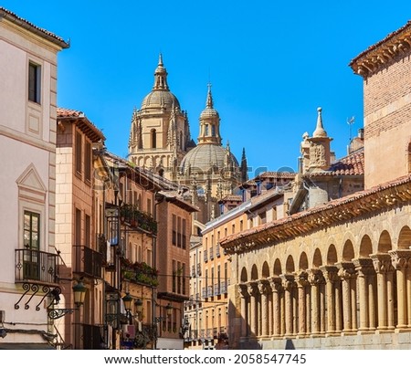 Domes of the Cathedral of Segovia with the Juan Bravo street and the atrium of the Romanesque church of San Martin in the foreground. View from Medina del Campo square. Segovia, Spain.