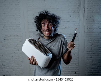 Domestic Accidents And Electricity Dangers. Young Man Electrocuted Trying To Fix A Toaster. Husband With Dirty Burnt Funny Face Expression After Getting An Electric Shock At Home.