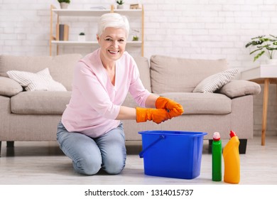 Domestic Chores. Cheerful Senior Woman Washing Floor At Home, Smiling At Camera With Rag