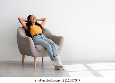Domestic Comfort. Portrait Of Happy Young Arab Woman Relaxing In Comfortable Armchair At Home, Beautiful Middle Eastern Female Sitting In Chair With Closed Eyes And Hands Behind Head, Copy Space - Shutterstock ID 2111887049