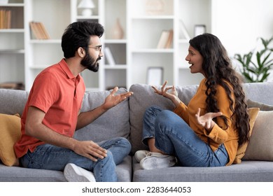 Domestic Conflicts. Portrait Of Young Indian Couple Arguing At Home, Millennial Eastern Spouses Suffering Relationship Problems And Misunderstanding, Sitting On Couch And Quarreling With Each Other - Powered by Shutterstock