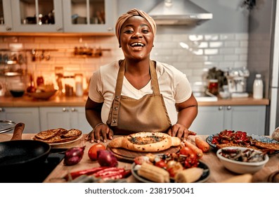 Domestic culinary. Cheerful african american woman in turban and apron standing behind kitchen table full of delicious traditional meals. Plus size housewife cooking at cozy home for beloved family. - Powered by Shutterstock