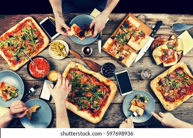 Domestic Food And Homemade Pizza. Enjoying Dinner With Friends. Top View Of Group Of People Having Dinner Together While Sitting At The Rustic Wooden Table