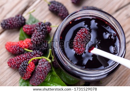 Domestic fresh mulberry jam on a rustic wooden board