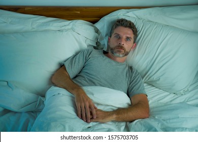 Domestic Lifestyle High Angle Portrait Of Young Handsome Man Awake At Night With Blue Eyes Wide Open Unable To Sleep Suffering Insomnia Sleeping Disorder Looking Stressed And Restless