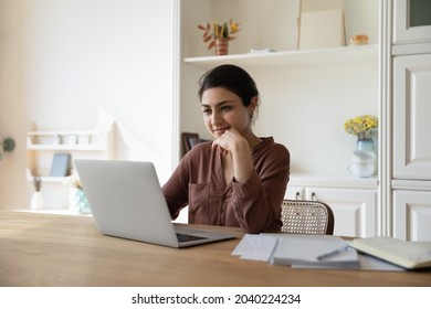 Domestic Office. Positive Millennial Indian Female Freelancer Work On Laptop From Home At Morning Check New Messages In Email Client. Pensive Young Lady Read Document Online Think On Business Offer