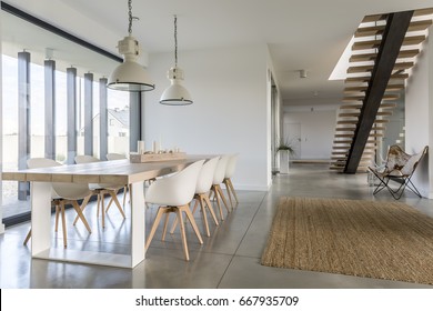 Domestic open space with dining table and wooden stairs