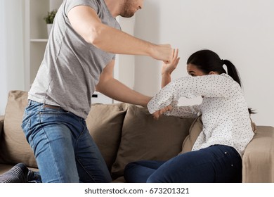 Domestic Violence, Abuse And People Concept - Couple Having Fight And Man Beating Helpless Woman At Home