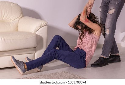 Domestic violence, abuse and victim concept - aggressive man dragging helpless woman by hair - Shutterstock ID 1383708374