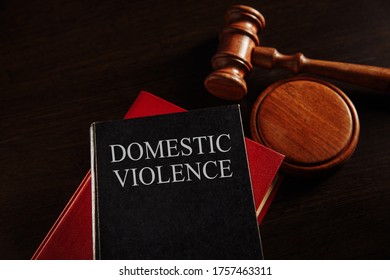 Domestic violence concept. Wooden gavel on the big red book. Juridical protection. - Shutterstock ID 1757463311