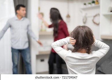 Domestic violence and Family conflict concept. Sadness little girl against blured of mother fighting father with quarrel at home.