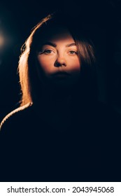 Domestic Violence. Woman Abuse. Female Slavery. Sexism Discrimination. Victim Lady Portrait Focus On Face In Soft Warm Light Shadow Contrast Isolated On Dark Free Space Background.