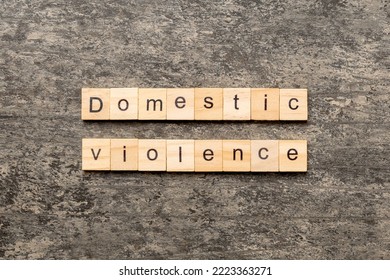 Domestic violence word written on wood block. Domestic violence text on cement table for your desing, Top view concept. - Shutterstock ID 2223363271