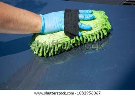 Domestic work: woman clean car in glowes with sponge in hand