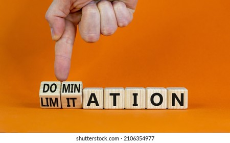 Domination or limitation symbol. Businessman turns cubes, changes the word domination to limitation. Beautiful orange table, orange background, copy space. Business, domination or limitation concept.
