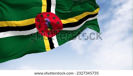 Dominica national flag waving on a clear day. Green field, a cross of yellow, black, and white, a red disk with a purple Sisserou Parrot, and ten green stars. 3d illustration render. Fluttering fabric