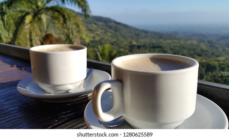 Dominican Coffee Cups In Focus Of Beautiful Country Side