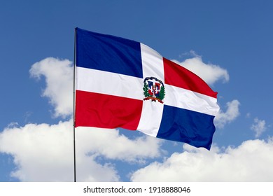Dominican flag isolated on the blue sky with clipping path. close up waving flag of Dominican. flag symbols of Dominican.