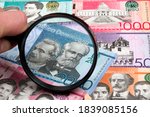 Dominican peso in a magnifying glass