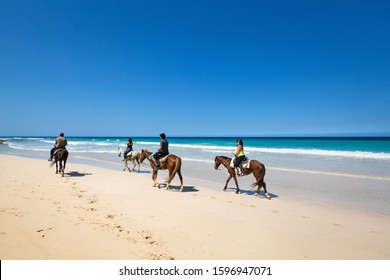 DOMINICAN REPUBLIC, PUNTA CANA - 20 MARCH 2019: People Riding Horses On Macao Beach. Famous Excursion For Tourists