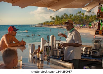 DOMINICUS, DOMINICAN REPUBLIC 6 FEBRAURY 2020: Dominican bartender prepares a cocktail on the beach