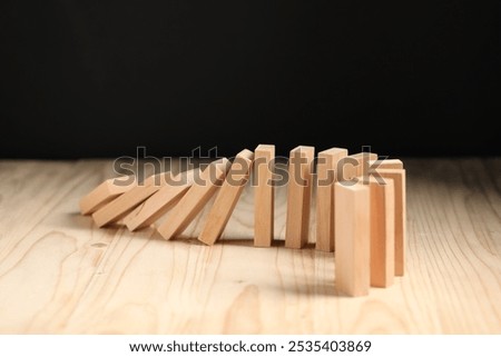 Domino effect. Blocks falling on wooden table